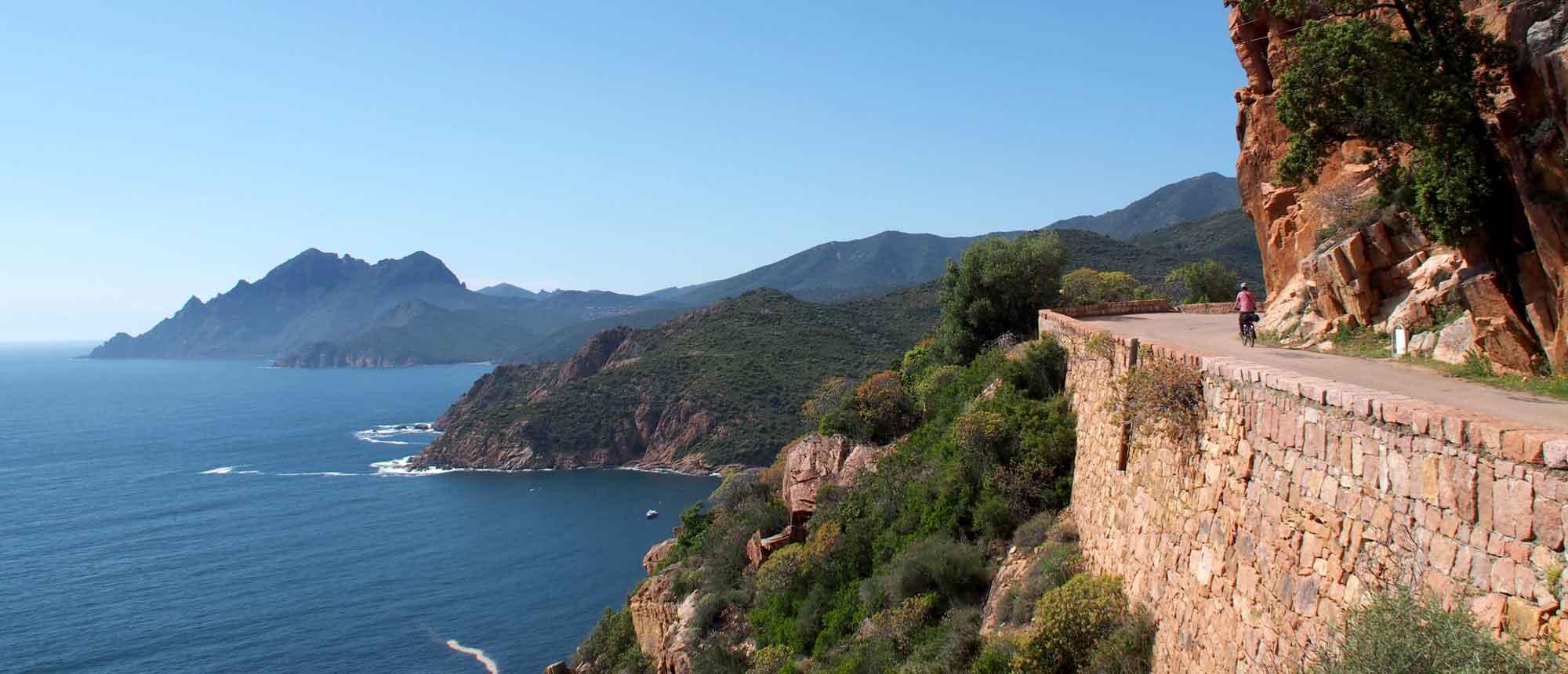 Cycliste sur route côtière en Corse